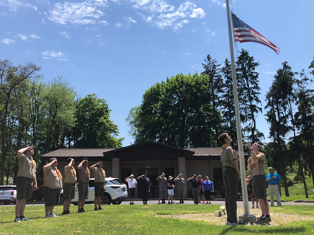 Boy Scout Troop 4027, American Legion Post 1420 members, Civilian Air Patrol cadets and community members and veterans salute the American flag, Saturday, at Cedar Hill Cemetery.